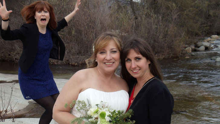 A group of women posing for a photo in front of a river

Description automatically generated with medium confidence