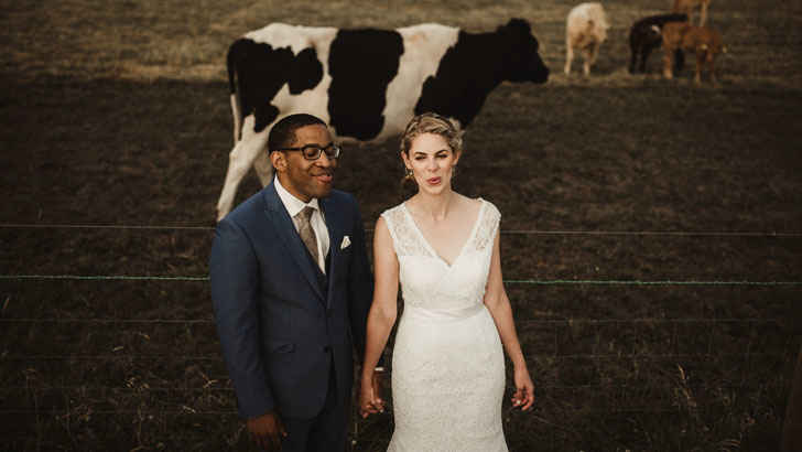 A person and person posing for a picture in front of a cow

Description automatically generated with medium confidence